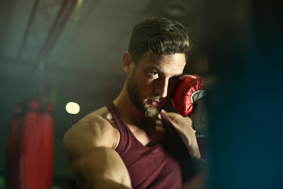 Boxer with a red glove raised to his face