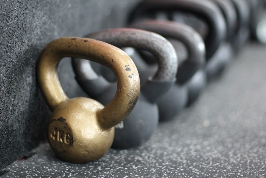 Cast-iron kettlebells lined up on rubber flooring