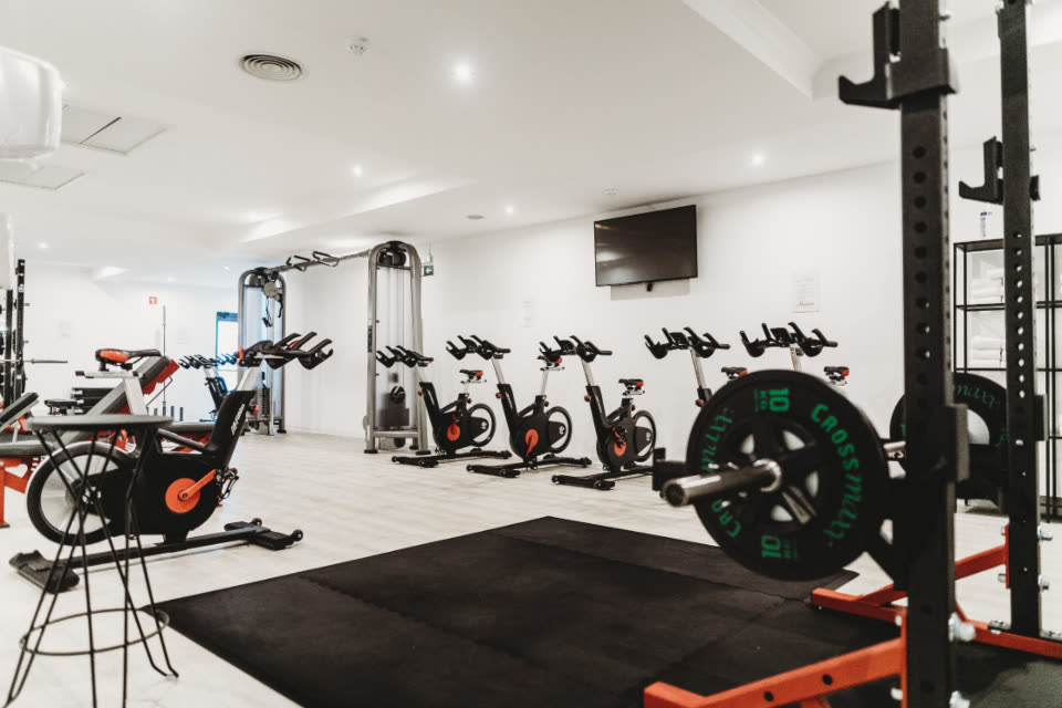 Open training floor with squat racks and bikes